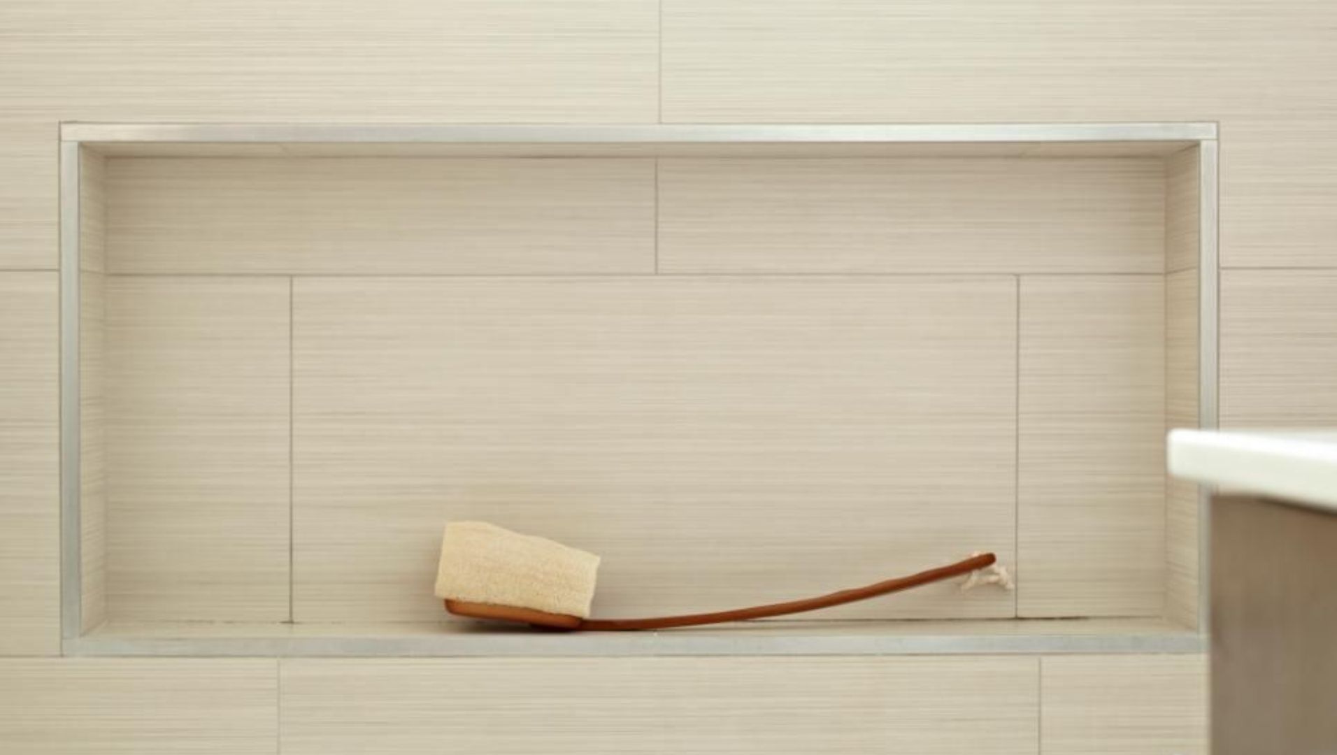 Close-up of aluminum tile trim in a modern bathroom setting