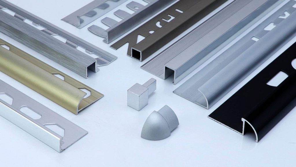 Close-up view of aluminum tile trims in various finishes and shapes