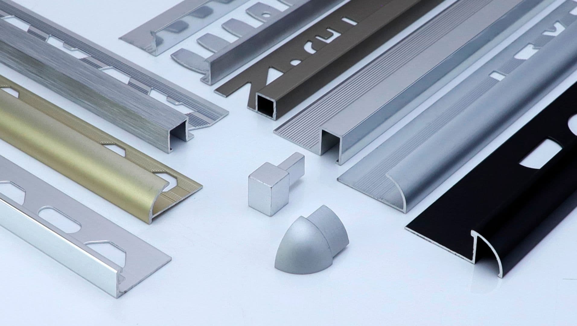 Close-up view of aluminum tile trims in various finishes and shapes