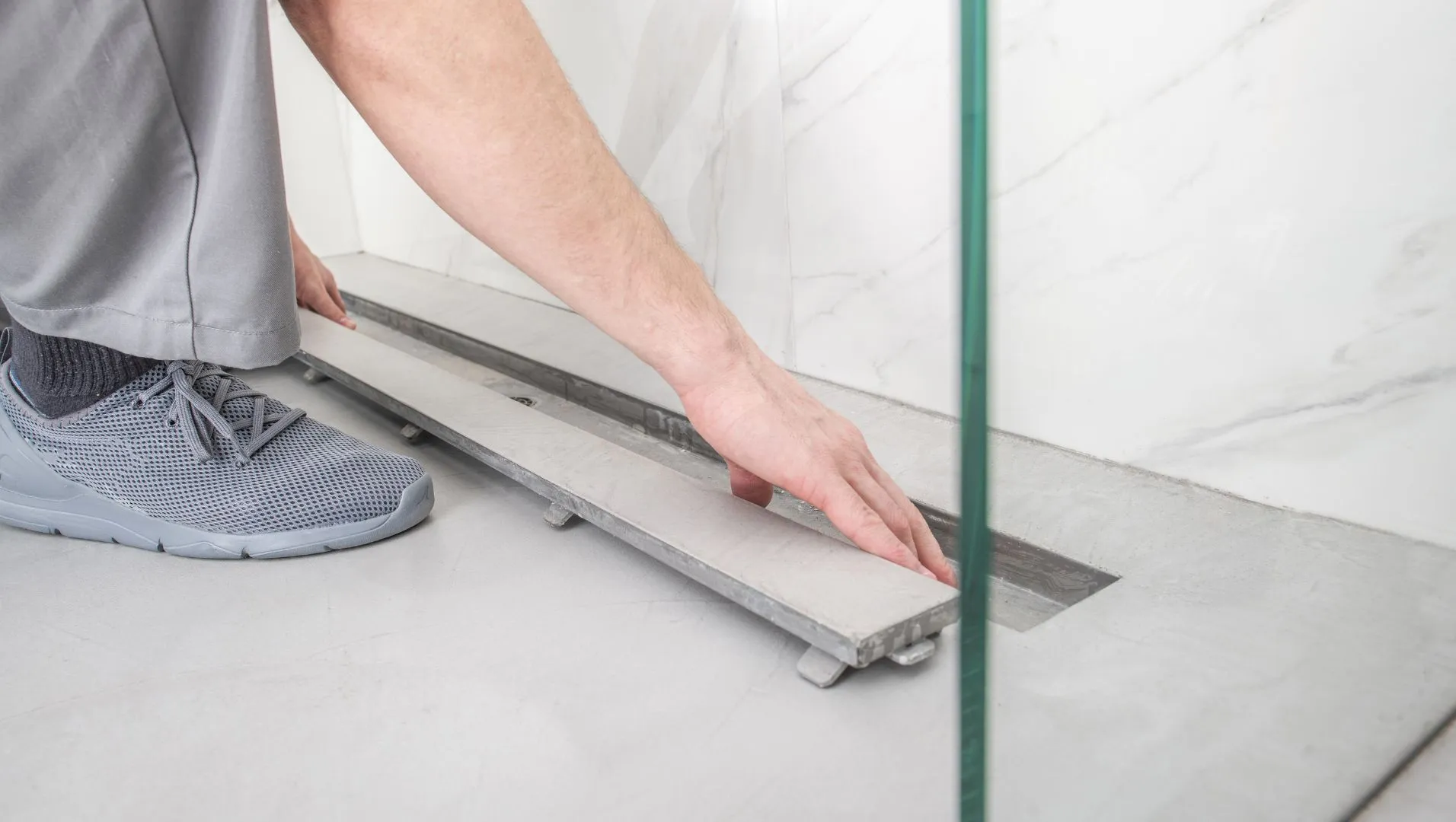 Illustration of a floor drain installation in a bathroom with details on slope and sealing.