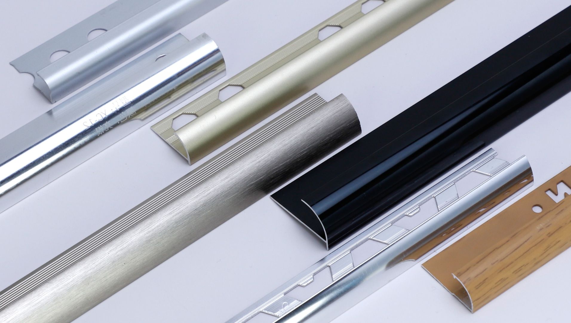 Close-up of metal tile trims in various finishes enhancing tiled surface