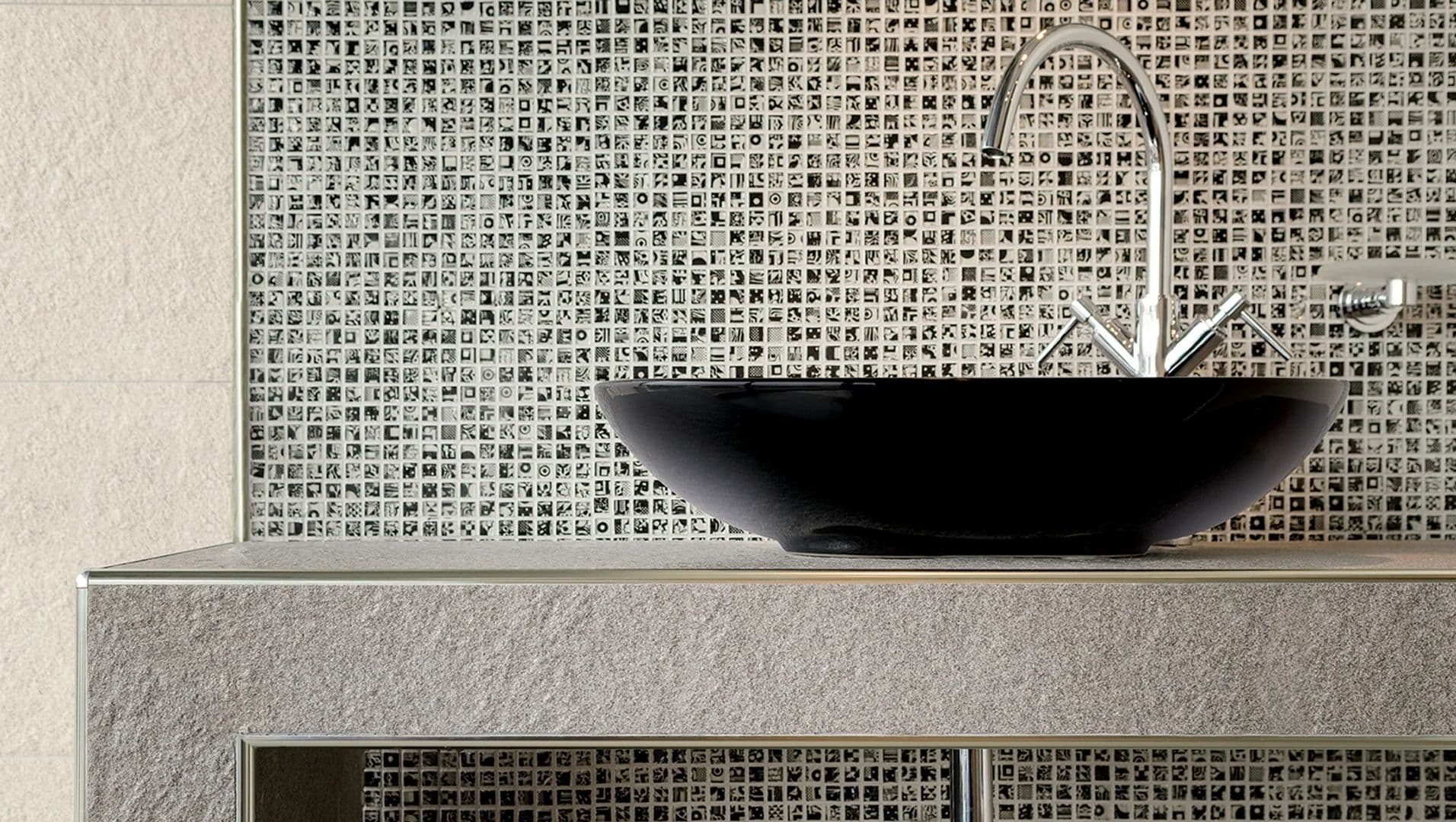 Close-up of brushed stainless steel tile trim in a modern bathroom