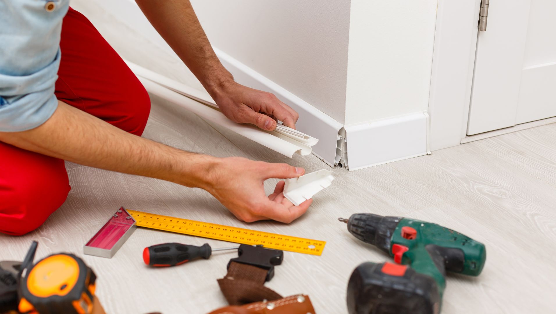 Close-up of a skirting board being installed against a wall