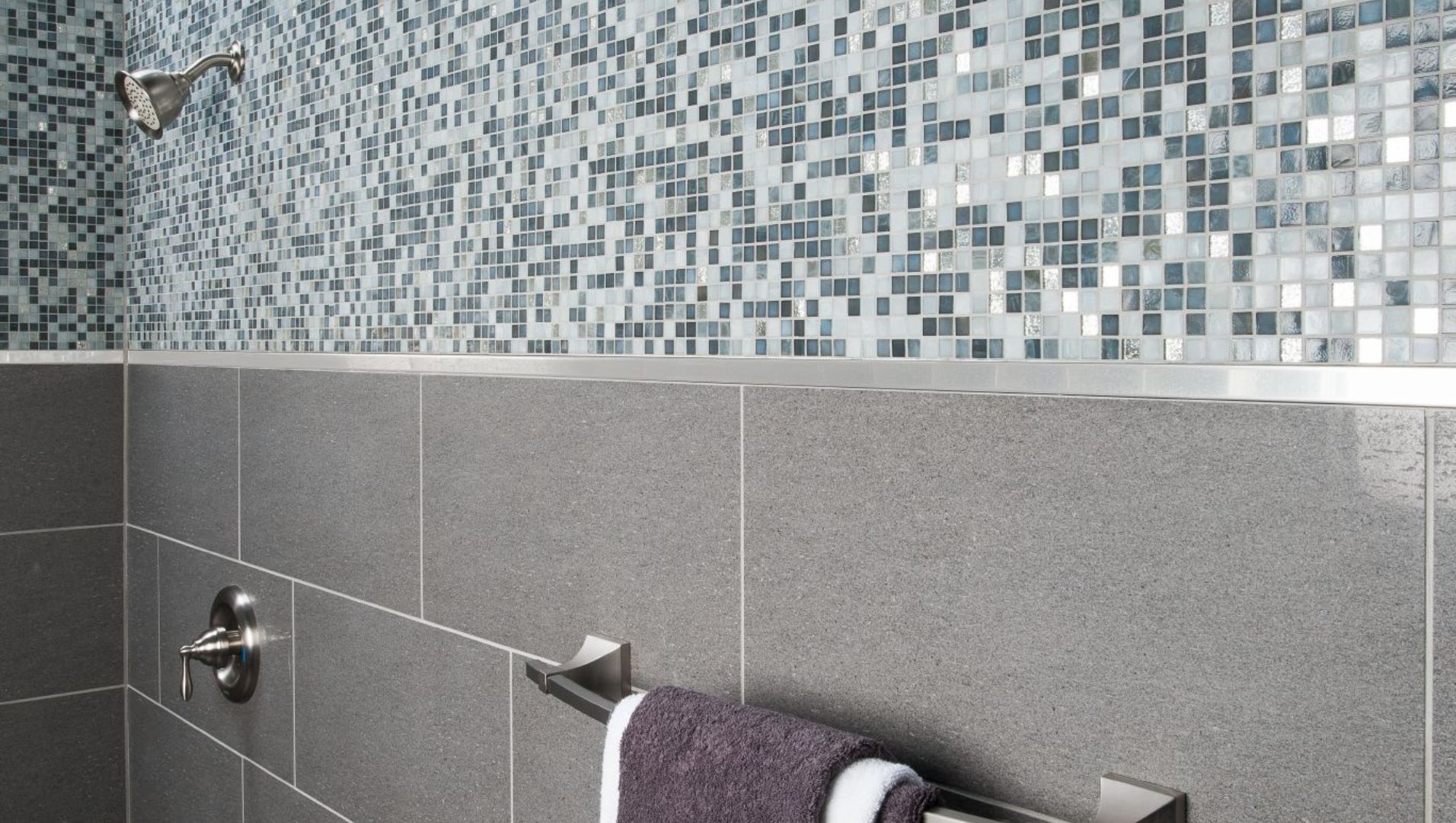 Close-up of a tiled wall with sleek metal Schluter tile trim