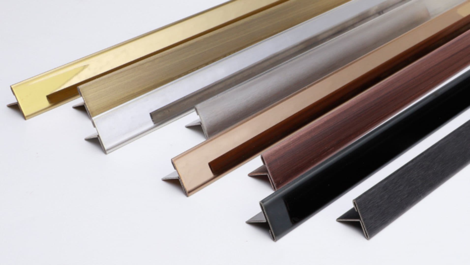 Artistic display of stainless steel tile trims in various shapes and finishes.
