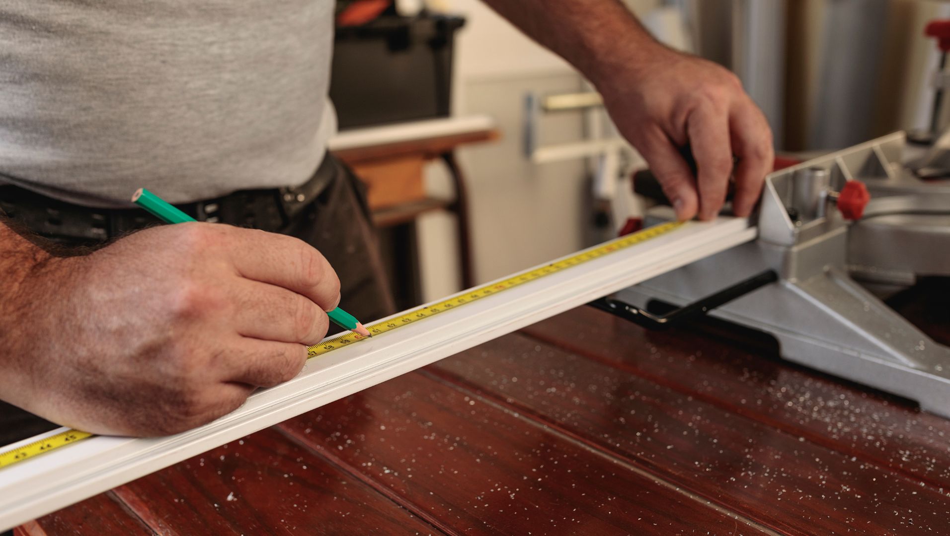 A variety of tile trims with measurement tools on a workbench.