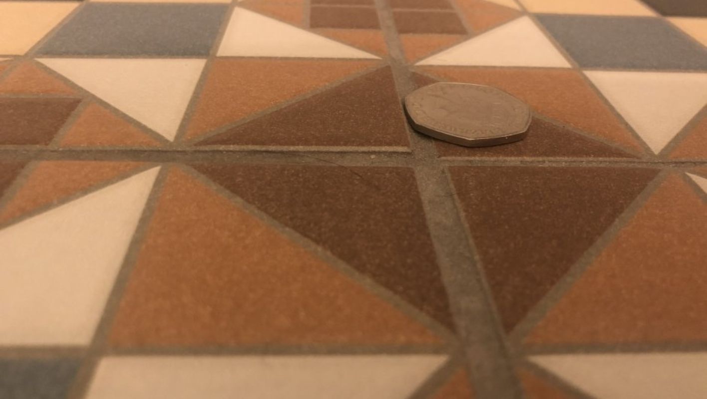 Close-up of a tiled floor showing uneven tiles