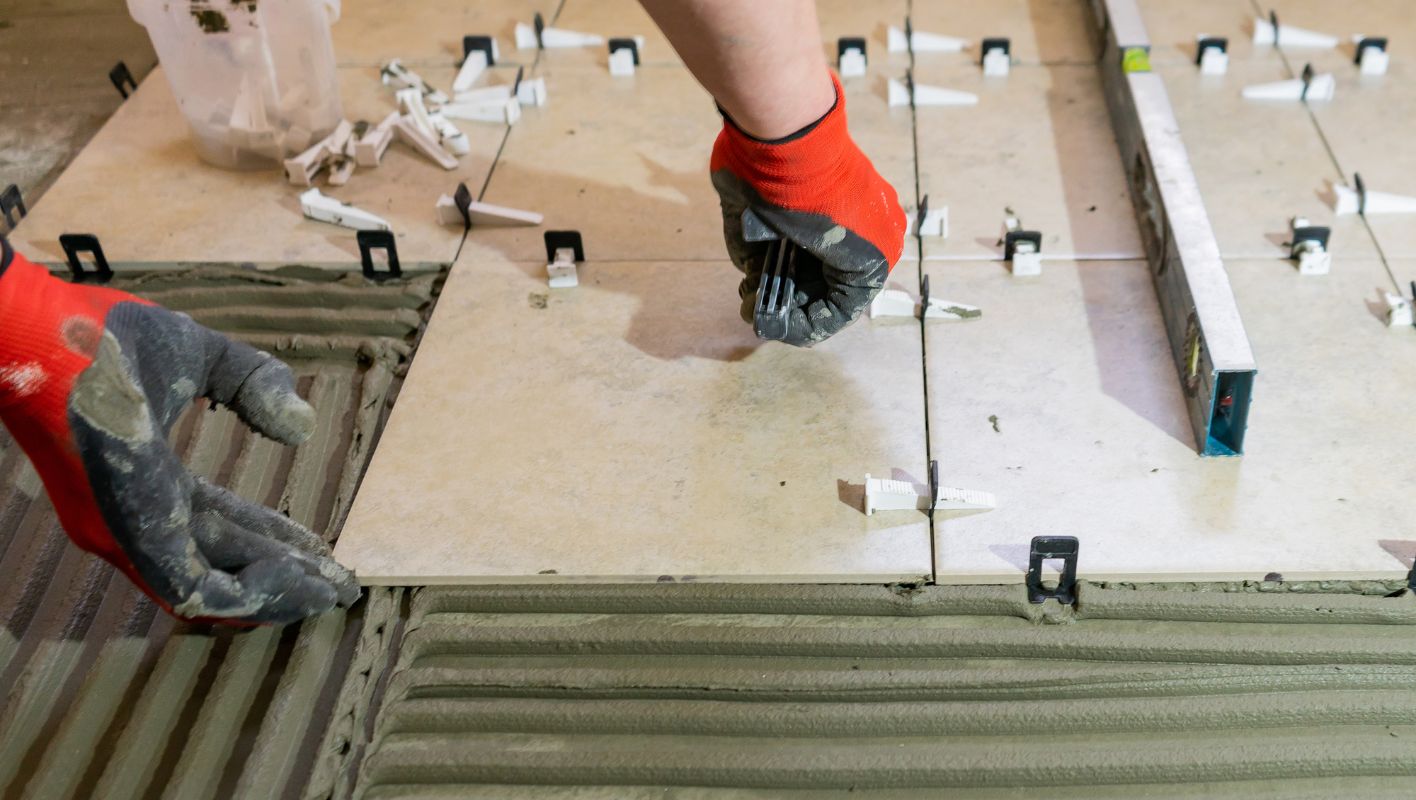 Close-up of a tiled floor with leveling system tools