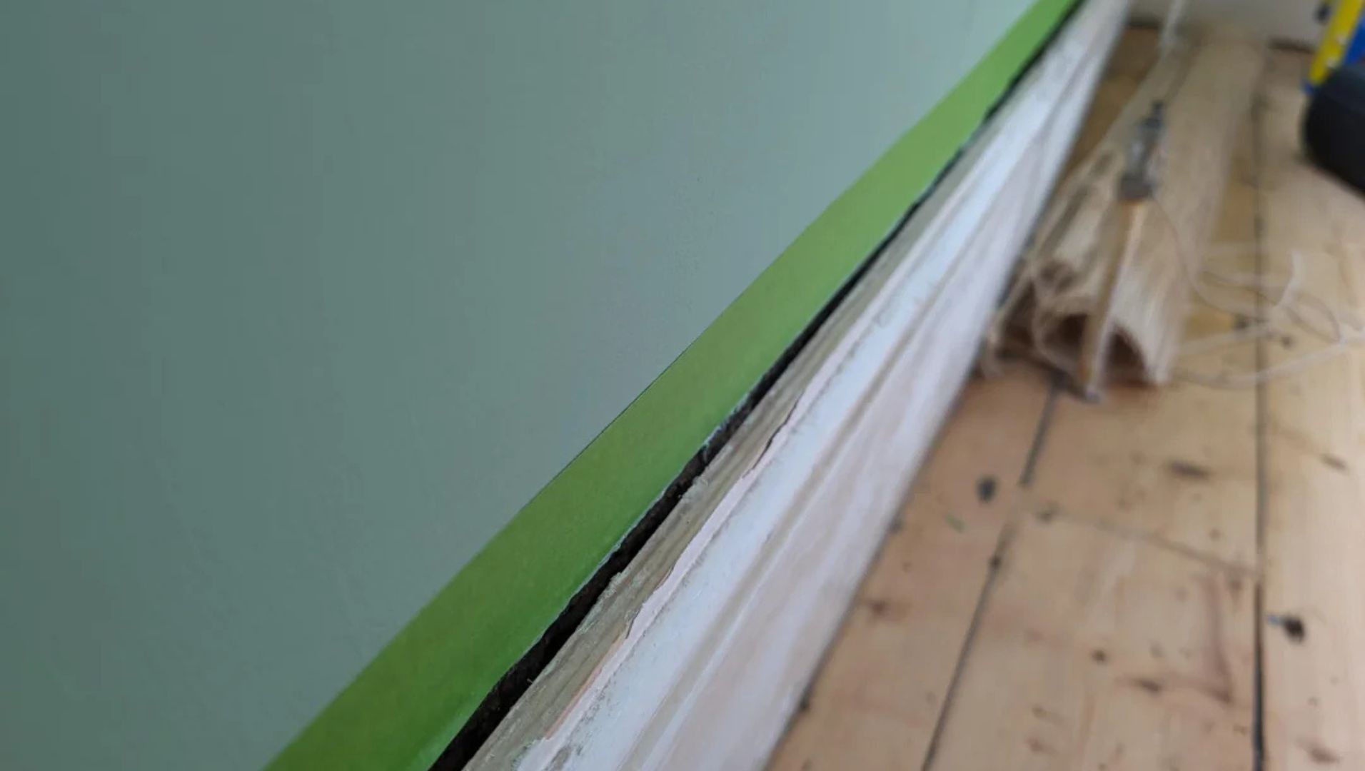Warped and detached skirting board due to moisture damage in a bathroom